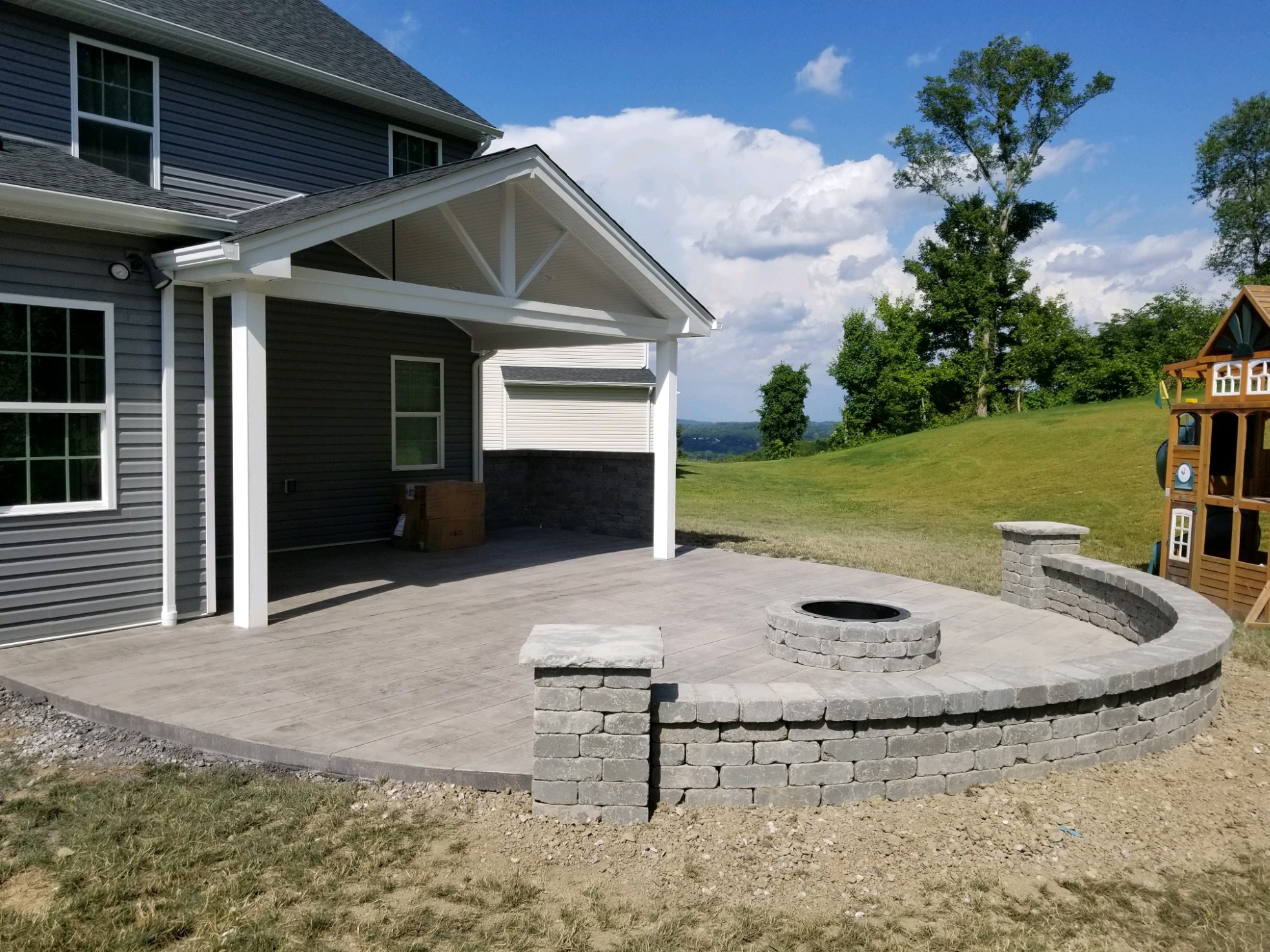 Stamped patio with fireplace and block wall