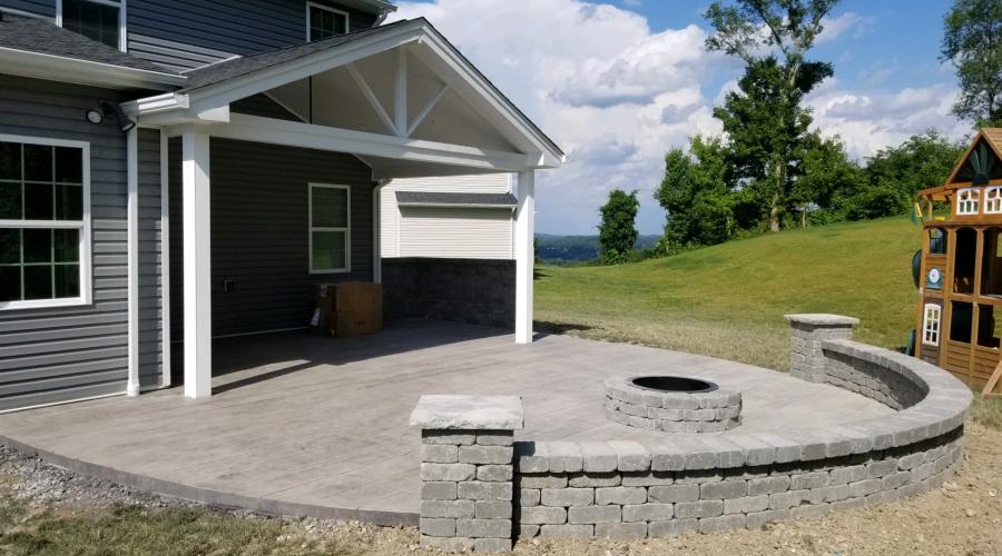 Stamped patio with fireplace and block wall